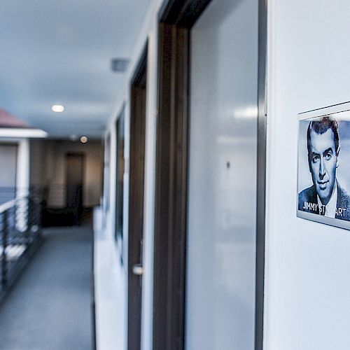 A hallway in what appears to be a motel or apartment complex, showing door number 236 with a black-and-white photo of a person next to it.