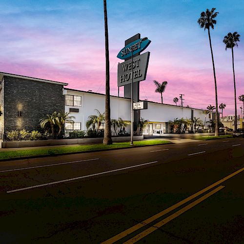 The image shows the exterior of the Sunset West Hotel at twilight, featuring palm trees and a neon sign against a colorful sky.